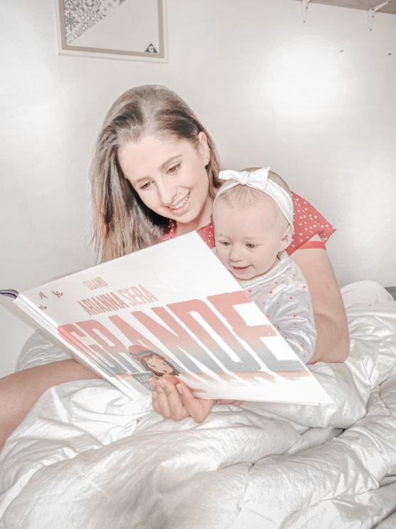 Une maman avec son enfant en train de lire le meilleur cadeau de la fête des mères.