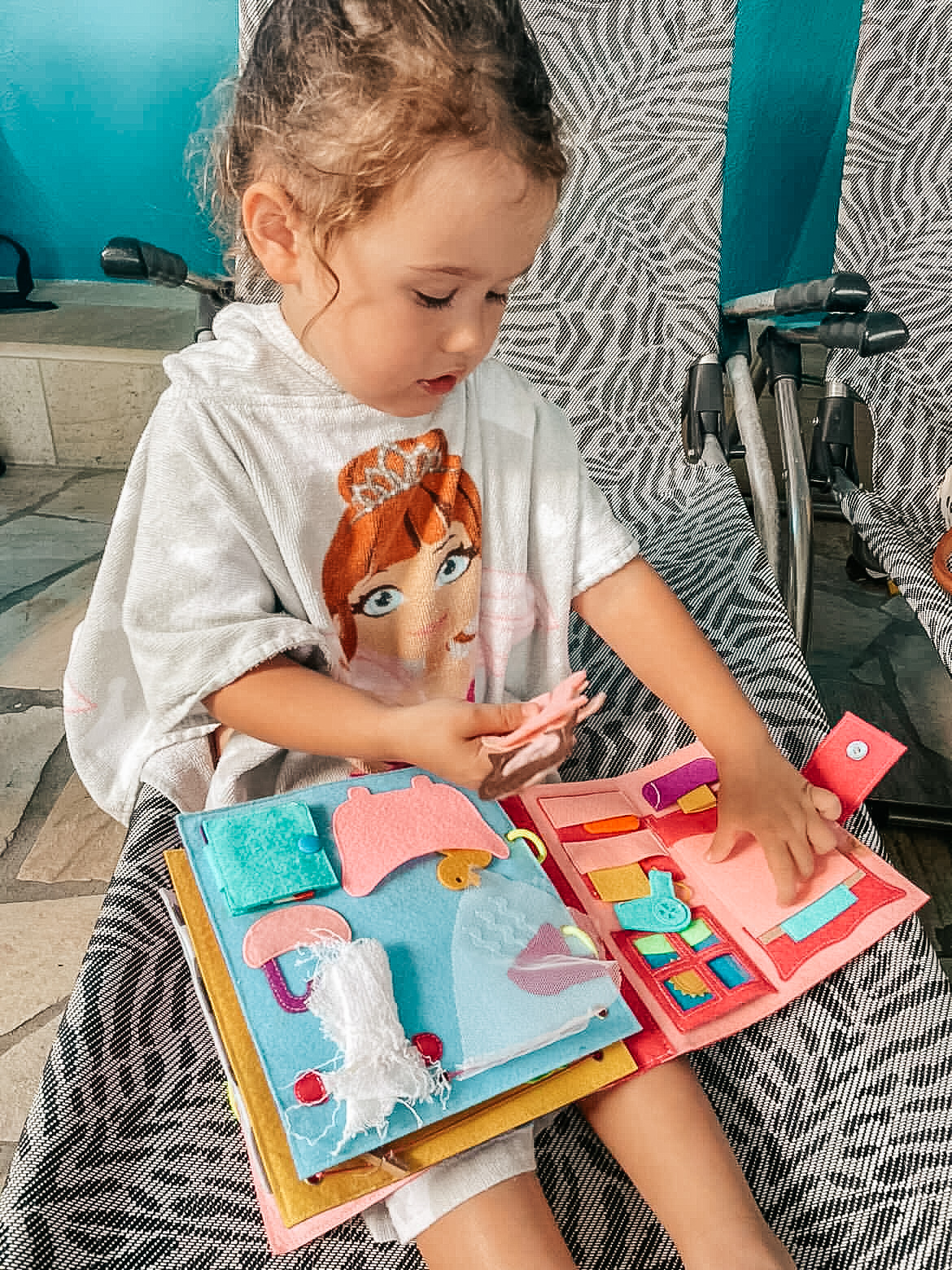 A little girl manipulating all the little items you will find in this personalized quiet book.