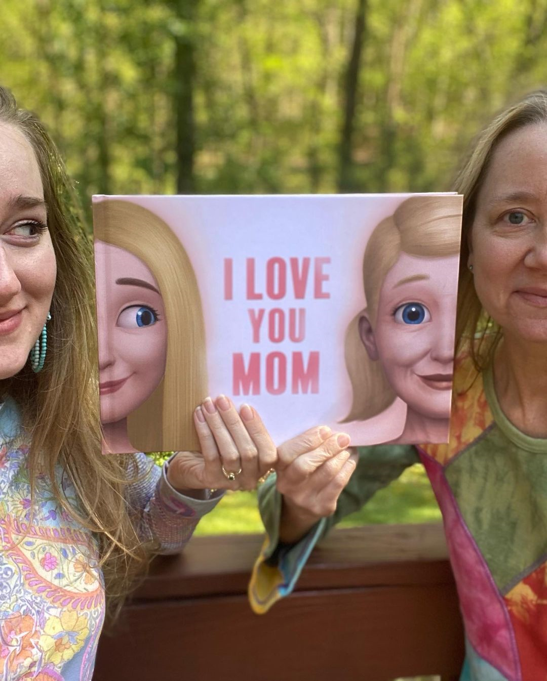 A daughter and her mom with their personalized book for Mother's day.