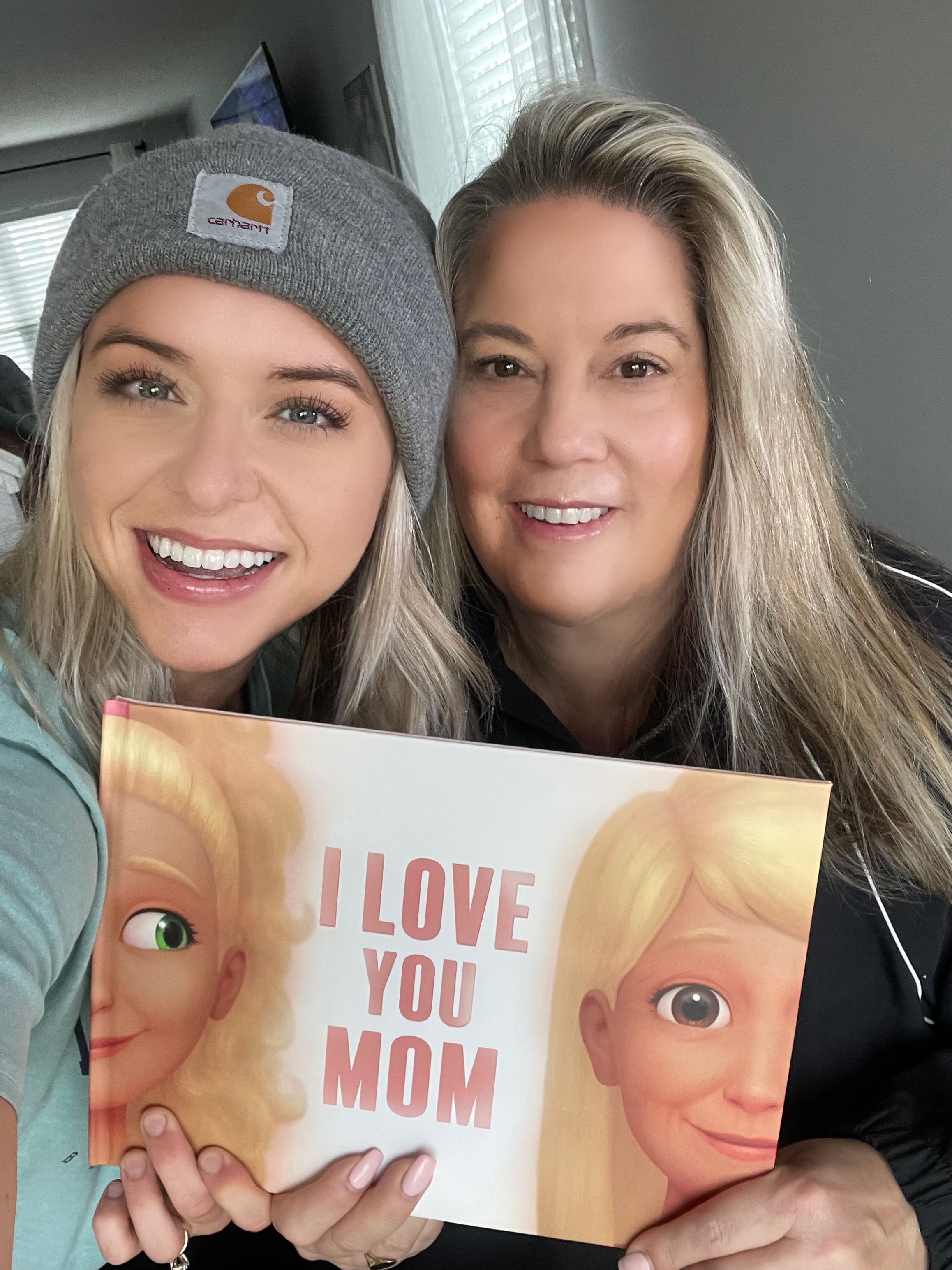 A mother and her daughter with the I love you Mom book from Hooray Heroes.