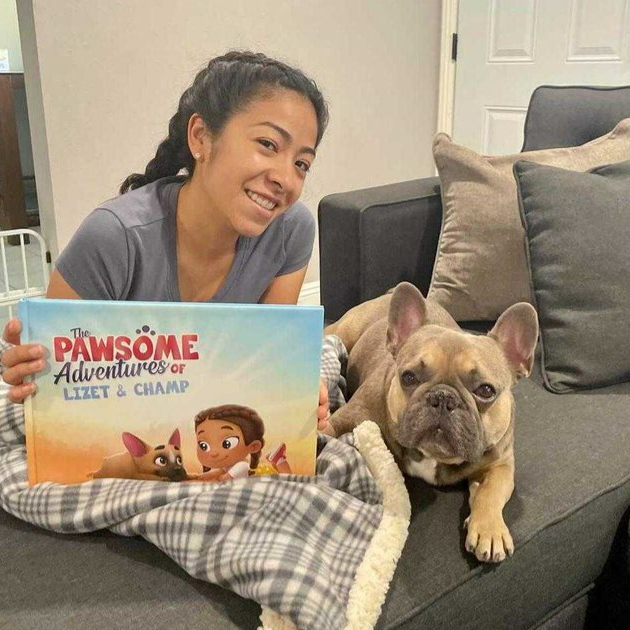 A woman reading her personalized pet book and petting her dog.